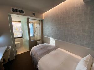 a bedroom with a bed and a bathroom at APA Hotel Keikyukamata Ekimae in Tokyo