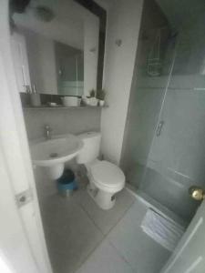 ein Bad mit einem WC und einem Waschbecken in der Unterkunft Apartamento pequeño y acogedor muy bien ubicado. in Quito