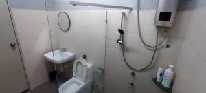 uma casa de banho com um chuveiro, um WC e um lavatório. em TAR HOMESTAY em Lahad Datu