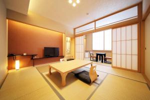 a living room with a wooden table and a room with a television at Hotel Honnoji in Kyoto