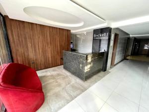 eine Lobby mit einem roten Stuhl und einer Theke in der Unterkunft Apto moderno y cómodo cerca del Mall Las Brisas in Santa Cruz de la Sierra + 13 Fotos