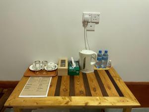 a wooden table with a coffee maker and water bottles at LETS GO HURAA in Huraa