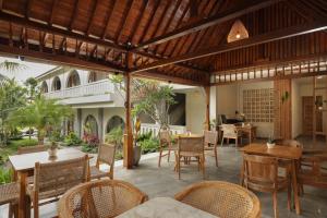 an outdoor dining area with tables and chairs at MAHALONA BALI STAY in Canggu