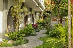 a garden with plants and a walkway at MAHALONA BALI STAY in Canggu