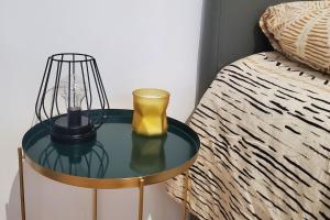 uma mesa de vidro com um candeeiro ao lado de uma cama em Tulsa Home - Superbe appartement de deux chambres - avec terrasse privée em Osny