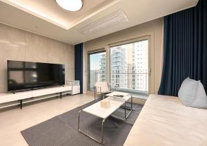 a hotel room with a large television and a bed at Y Collection by UH FLAT Osiria in Busan