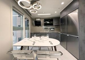 a kitchen with a table and chairs and a refrigerator at Y Collection by UH FLAT Osiria in Busan