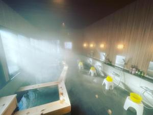 a bathroom with a bath tub with a mist of water at Kirishimaya Ryokan in Kusatsu