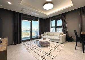 a living room with a couch and a table at Y COLLECTION by UH FLAT OSIRIA in Busan