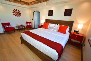 a bedroom with a large bed and two red chairs at Peppertree Lane Ranch -- Seven-Acre Ranch in the Heart of Wine Country in Temecula