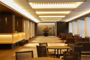 a dining room with tables and chairs and flowers at Hotel Honnoji in Kyoto
