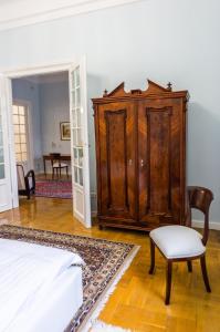 a bedroom with a wooden cabinet and a chair at Luxury Downtown 3 Bedroom Apartment by Synagoge with Beautiful View in Budapest
