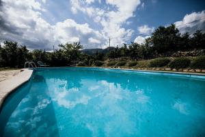 duży błękitny basen z pochmurnym niebem w obiekcie Mas Fullat cottage, Alforja tarragona w mieście Alforja