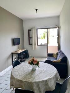 a living room with a table and a couch at Apartmento em Praia de Guaibim in Guaibim