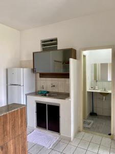 a kitchen with a white refrigerator and a sink at Apartmento em Praia de Guaibim in Guaibim