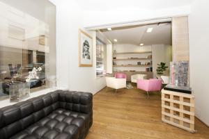 een woonkamer met een leren bank en roze stoelen bij Hotel Touring in Pisa