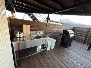a kitchen with a sink and a grill on a deck at Glamping Dome YOSHIMURA in Fujikawaguchiko