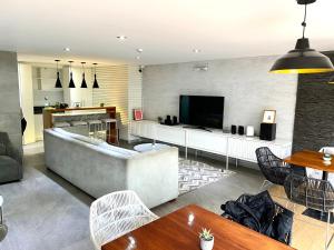 a living room with a large couch and a tv at Hermoso apartamento con piscina Miraflores- Canvas in Lima