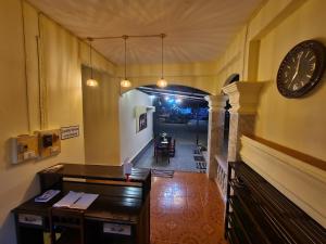 an office with a desk and a clock on the wall at Saphaothong guesthouse in Vang Vieng