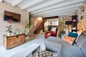 uma sala de estar com um sofá e uma mesa em Maison Saint-Thomas em Cuiseaux