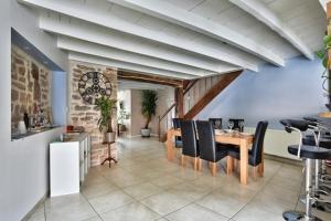 a dining room with a table and black chairs at Maison Saint-Thomas in Cuiseaux