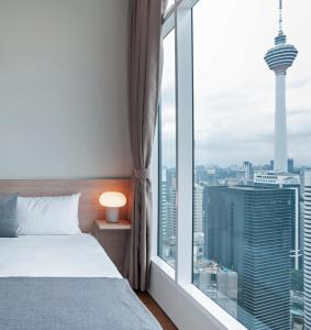 a bedroom with a bed and a large window at Soho Suites KLCC by Leala in Kuala Lumpur