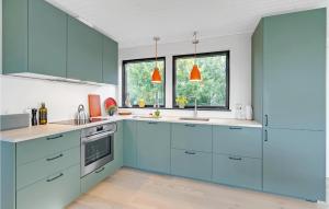 a kitchen with blue cabinets and windows at Two-Bedroom Holiday Home In Bogo By in Bogø By +31 photos