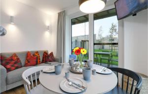 ein Wohnzimmer mit einem Tisch, Stühlen und einem Sofa in der Unterkunft Gorgeous Apartment In Lembruch-dmmer See With Kitchen in Lembruch