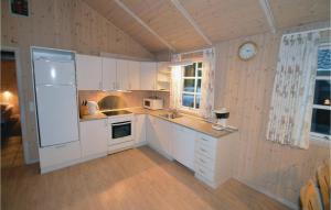 ErtebølleにあるGorgeous Home In Fars With Wifiの白いキャビネットと壁掛け時計付きのキッチン