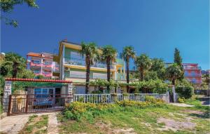 an apartment building with palm trees and a gate at Cozy Apartment In Crikvenica With Wifi in Crikvenica