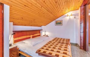 a bedroom with a bed with a wooden ceiling at Cozy Apartment In Crikvenica With Wifi in Crikvenica