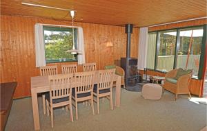 une salle à manger avec une table et des chaises en bois dans l'établissement Holiday Home Blavand With Sauna 294, à Blåvand