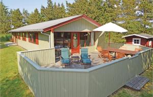 une terrasse avec des chaises, une table et un parasol dans l'établissement Holiday Home Blavand With Sauna 294, à Blåvand 23 autres photos