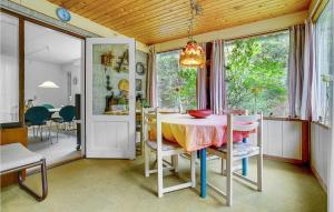 a kitchen and dining room with a table and chairs at Holiday Home Skovlindvej Iii in Marielyst +17 photos
