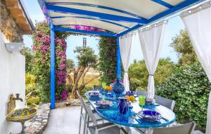 サンタ・カテリーナ・デッロ・イオーニオにあるVilla Acquaroの花の咲くパティオ(青いテーブル、椅子付)