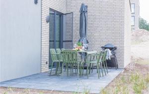 a table and chairs with an umbrella on a patio at Beautiful Home In Lembruchdümmer See in Lembruch