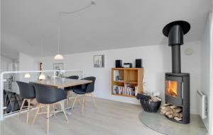 Egernsundにある3 Bedroom Gorgeous Home In Egernsundのダイニングルーム(暖炉、テーブル、椅子付)