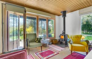 a living room with two chairs and a fireplace at Awesome Home In Fårevejle With Kitchen in Fårevejle