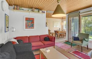 a living room with a red couch and a table at Awesome Home In Fårevejle With Kitchen in Fårevejle