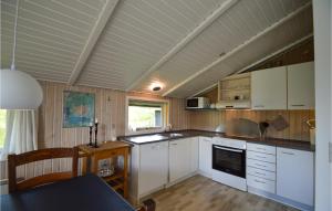 BolilmarkにあるNice Home In Rm With Saunaの白いキャビネットとテーブル付きのキッチンが備わります。