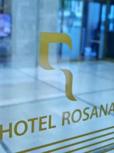 a gold logo on top of a hotel roma sign at Rosana Hotel in Seoul