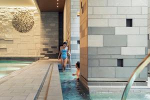 a woman and a child in the water in a swimming pool at Four Seasons Hotel Kyoto in Kyoto
