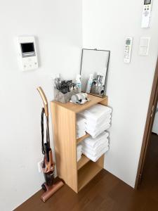 a shelf with a mirror and a pile of towels at HOTELグランシャインYAIMA in Ishigaki Island
