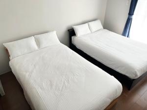 two beds sitting next to each other in a room at HOTELグランシャインYAIMA in Ishigaki Island