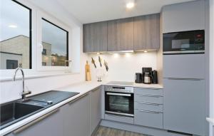 a white kitchen with a sink and a stove at Cozy Home In Lembruchdümmer See in Lembruch