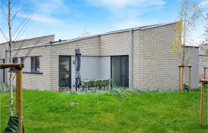 a brick house with two chairs and an umbrella at Cozy Home In Lembruchdümmer See in Lembruch +38 photos