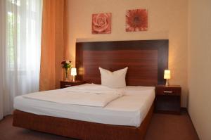 1 dormitorio con 1 cama grande y cabecero de madera en Hotel Albertin, en Berlín