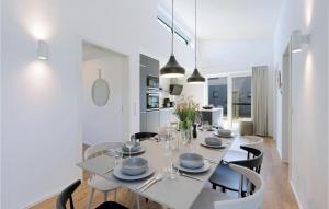 a white dining room with a white table and chairs at Awesome Home In Lembruch-dmmer See With Kitchen in Lembruch