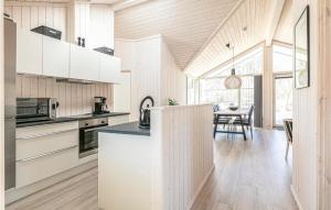 a kitchen with white cabinets and a dining room at 3 Bedroom Awesome Home In Hasle in Hasle