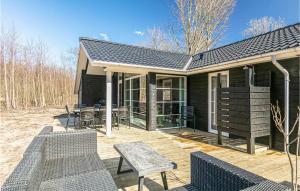 a house with chairs and tables on a deck at 3 Bedroom Awesome Home In Hasle in Hasle